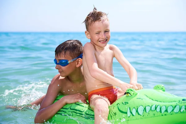 Niño de adolescentes con gafas de agua nada en el juguete inflable CROCODILE. . — Foto de Stock