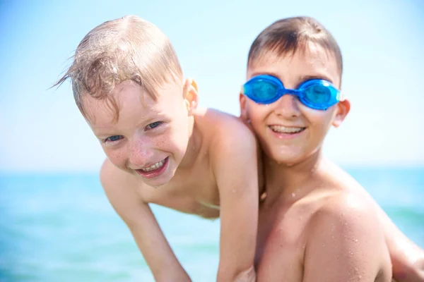 LOS NIÑOS HERMANOS JUGAN EN AGUA DEL MAR, VERANO — Foto de Stock