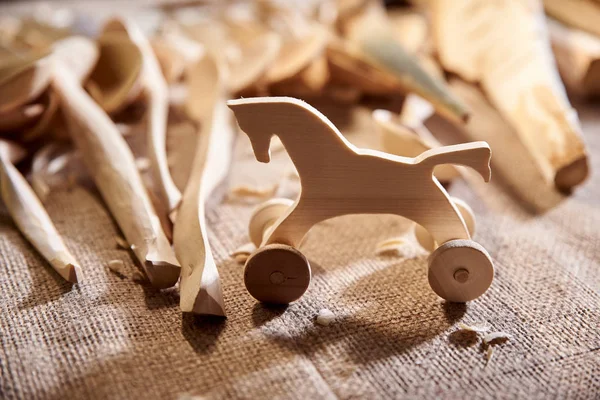 Toy statyett häst snidad i trä, en snickare i verkstaden — Stockfoto