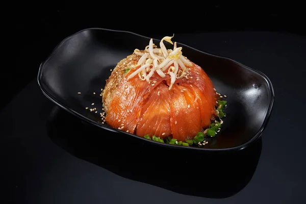 Steamed rice and salmon fillet with soybean sprouts on a black p — Stock Photo, Image