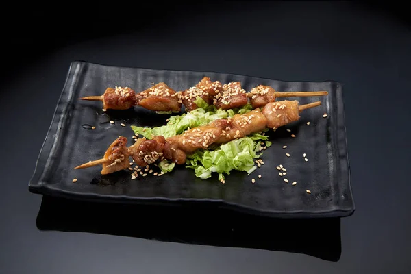 Mini kebabs on a black plate on a dark background — Stock Photo, Image