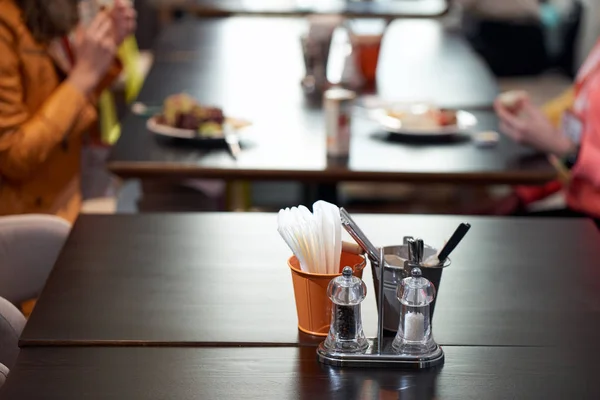 Salt shaker guardanapos de pimenta em uma mesa em um café — Fotografia de Stock