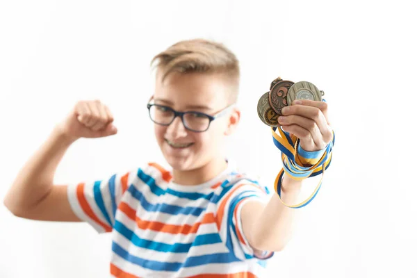 少年は感情的に喜び 勝利を祝い 彼の手に異なるメダルを保持します — ストック写真
