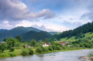 köy dağlar arka planda nehir kıyısında. Karpatlar Ukrayna