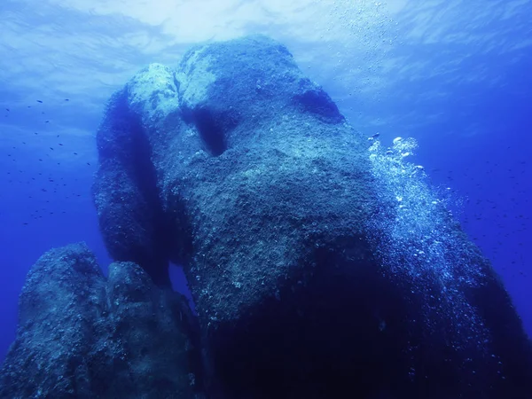 Antecedentes de uma rocha enorme submersa no mar — Fotografia de Stock