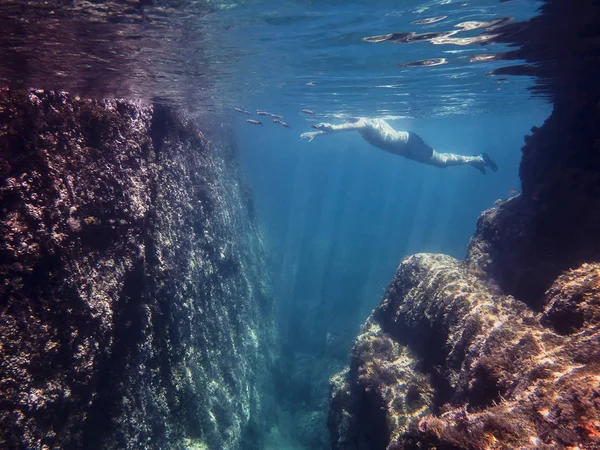 Hombre nadando en el mar visto desde debajo del agua — Foto de Stock