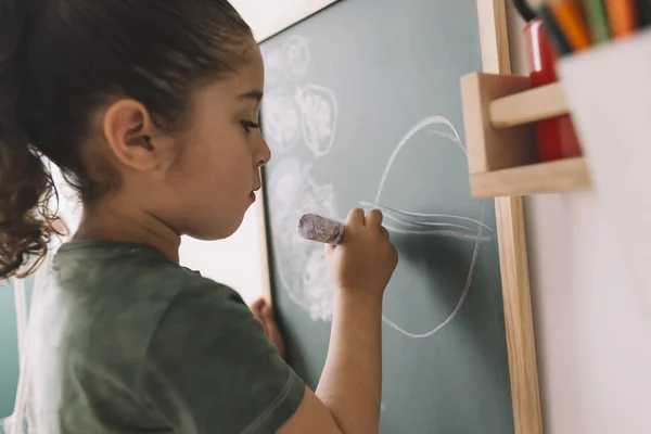 Little girl drawing on the blackboard — Stock Photo, Image