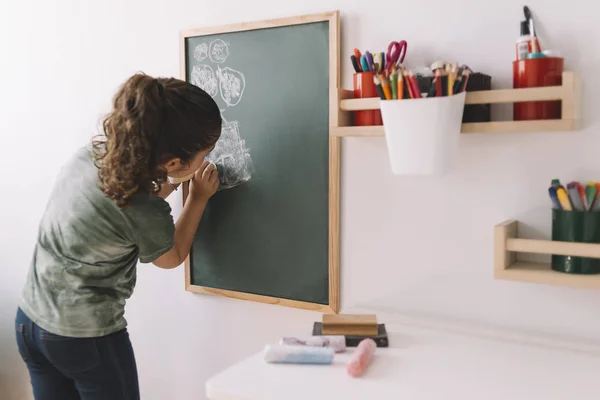 Petite fille dessin sur un tableau à la maison — Photo