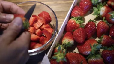 Şef el ve bıçak, ahşap kesim masasında taze çilek dilimleme, sağlıklı tatlı yiyecekler, vitaminler ve meyve konsepti.