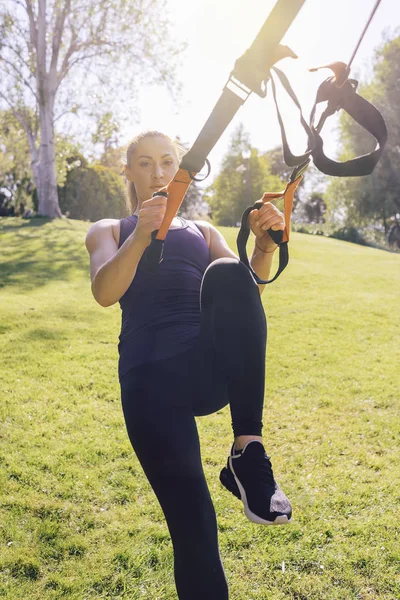 Atraente jovem mulher exercitando com equipamento — Fotografia de Stock
