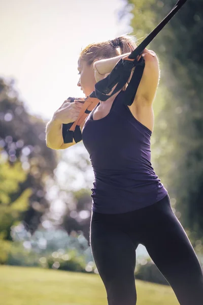 Treinamento de mulher atlética com tiras de fitness — Fotografia de Stock