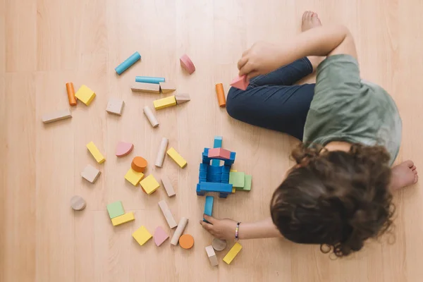 Chica jugando en el suelo con bloques de construcción —  Fotos de Stock