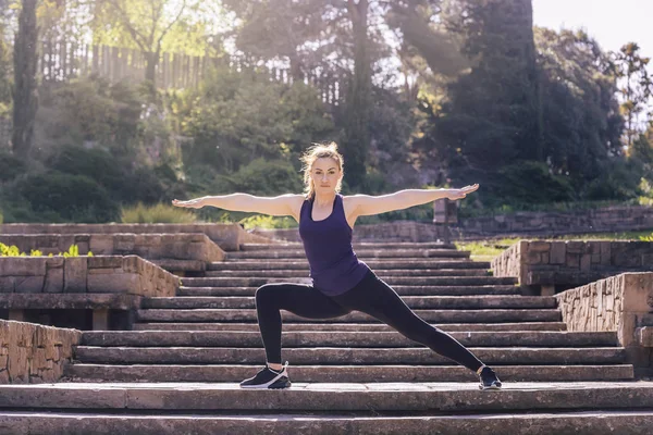 Mulher fazendo ioga posar nas escadas do parque — Fotografia de Stock