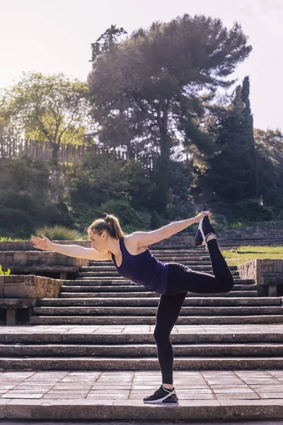 Mulher esportiva fazendo exercício de equilíbrio de ioga no parque — Fotografia de Stock