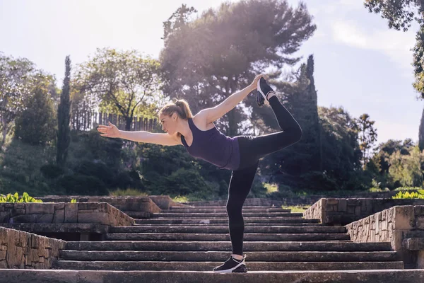 Menina esportiva fazendo exercício de equilíbrio de ioga no parque — Fotografia de Stock