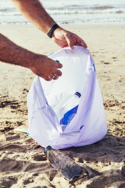 Sahilde plastik toplayan bir gönüllü el
