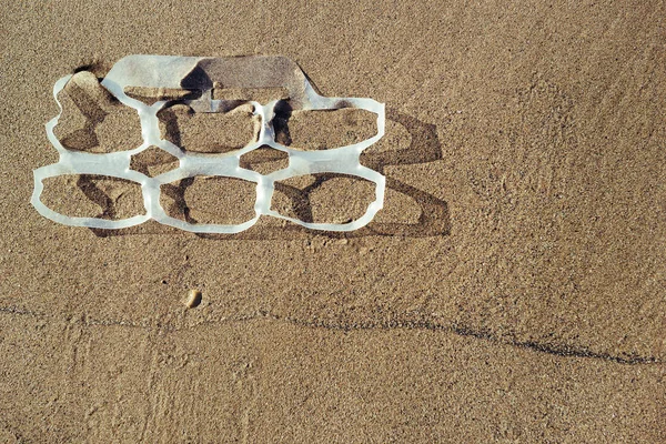 plastic rings in the sand of the beach