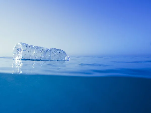 deniz yüzeyinde yüzen plastik şişe