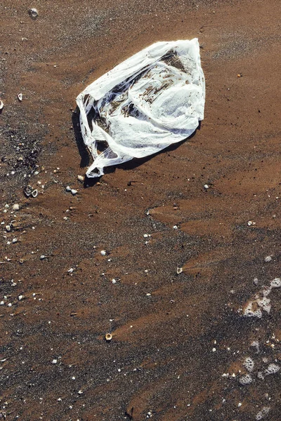 塑料袋污染海滩的沙滩 — 图库照片