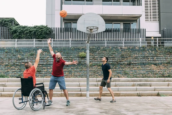 Behinderter Mann spielt Basketball mit zwei Freunden — Stockfoto