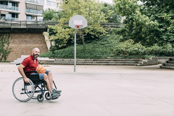 Hombre en silla de ruedas jugando en la cancha de baloncesto —  Fotos de Stock