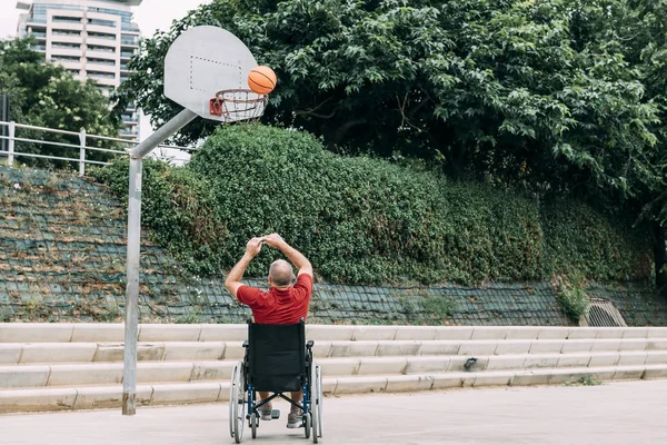 handicapped man playing basketball alone