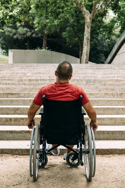 Чоловік у інвалідному візку зупинився перед сходами — стокове фото