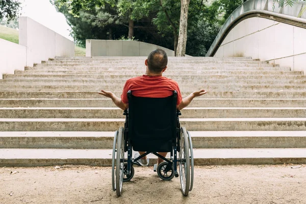 Man in wheelchair outraged in front of stairs — Stock Photo, Image