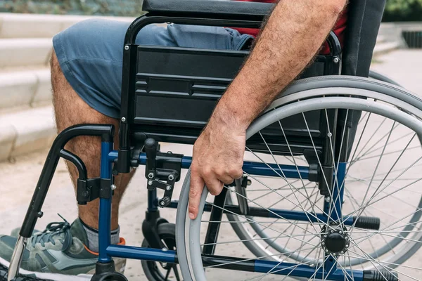 Людина в інвалідному візку з рукою на кермі — стокове фото