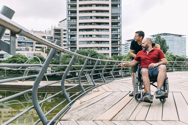 Mężczyzna na wózku inwalidzkim rozmawia ze swoim przyjacielem — Zdjęcie stockowe
