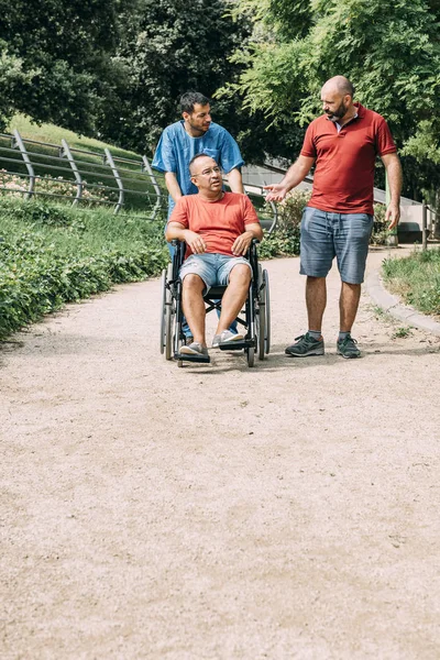 tekerlekli sandalyede adam hemşiresi ve bir arkadaşı ile konuşmak