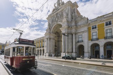 Lizbon'da zafer kemeri önünden geçen tramvay