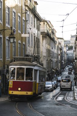 Lizbon 'da tipik dar bir sokakta tramvay ve arabalar