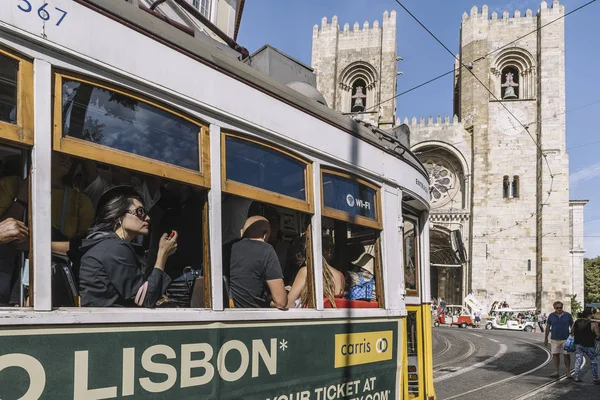 Lizbon katedrali önünde tramvay ile turistler