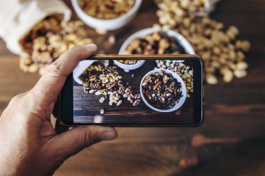 Yemek blogcusu telefonla karışık fındık fotoğrafı çekiyor