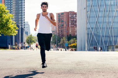 Şehirdeki asfaltta koşan bir sporcunun ön görüntüsü, şehir sporu ve sağlıklı yaşam tarzı kavramı, metin için kopyalama alanı