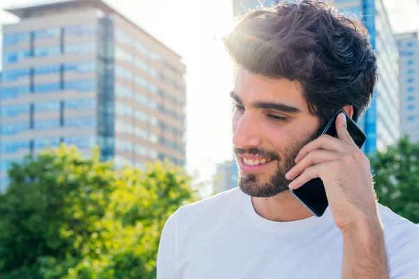 Portret Przystojnego Młodzieńca Uśmiechającego Się Rozmawiającego Przez Telefon Zachodzie Słońca — Zdjęcie stockowe