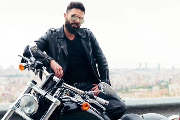 Deri giyen ve güneş gözlüğü takan bir adam motosikletinin yanında poz veriyor, özgürlük ve motorcu yaşam tarzı, metin için kopyalama alanı