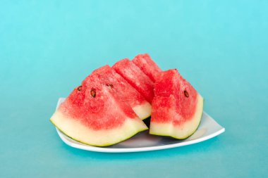 Mavi arka planda bir tabakta karpuz dilimleri. Lezzetli, taze yaz tatlısı. Stok fotoğrafı