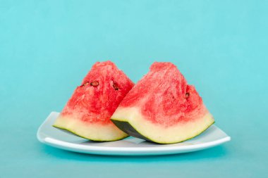 Mavi arka planda bir tabakta karpuz dilimleri. Lezzetli, taze yaz tatlısı. Stok fotoğrafı