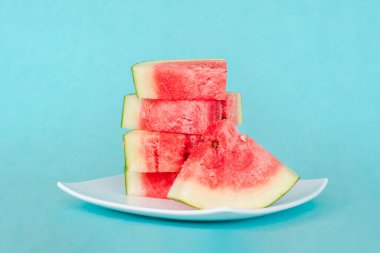 Mavi arka planda bir tabakta karpuz dilimleri. Lezzetli, taze yaz tatlısı. Stok fotoğrafı
