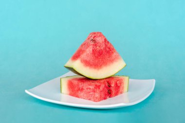 Mavi arka planda bir tabakta karpuz dilimleri. Lezzetli, taze yaz tatlısı. Stok fotoğrafı