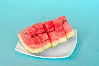 Mavi arka planda bir tabakta karpuz dilimleri. Lezzetli, taze yaz tatlısı. Stok fotoğrafı