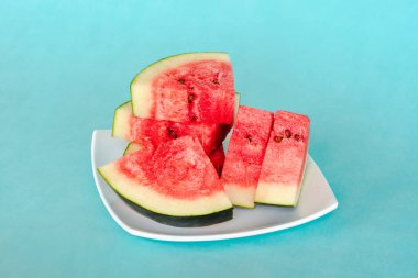 Mavi arka planda bir tabakta karpuz dilimleri. Lezzetli, taze yaz tatlısı. Stok fotoğrafı