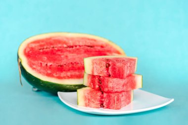 Mavi arka planda bir tabakta karpuz dilimleri. Lezzetli, taze yaz tatlısı. Stok fotoğrafı