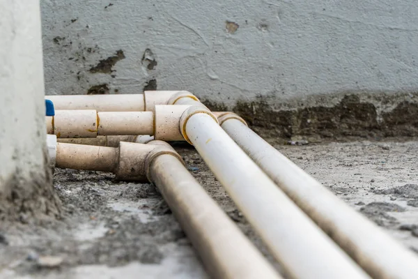 White plastic water pipes with blue faucet, parts of a home water supply system, close up stock photo