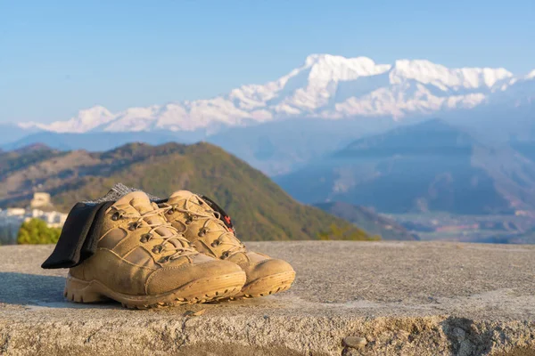 Tourist Hiking shoes with socks with Annapurna range snowy peaks on background. Mountain Trekking and Hiking, travel and tourism concept. Close-up stock photo.