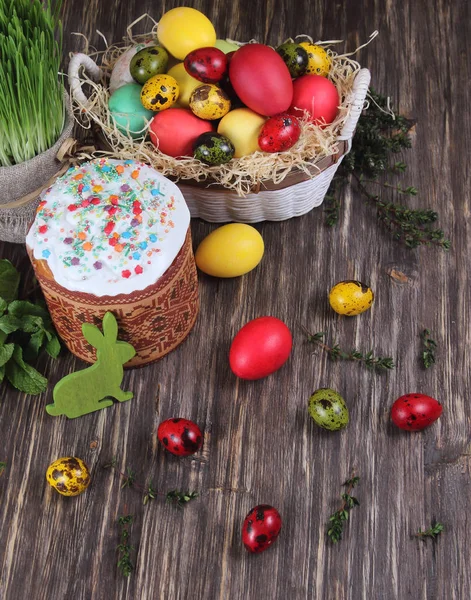 Пасхальный торт и разноцветные яйца на деревянном фоне — стоковое фото