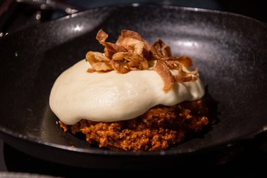 Süsleme olarak üstünde çıtır soğan olan et suflesi.