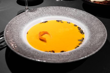 Zarif bir restoranda servis edilen çekirdekli kabak portakalı çorbası.